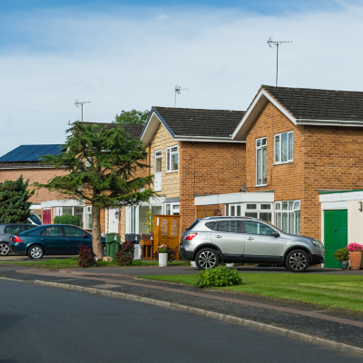 Suburban residential street with cars parked outside houses