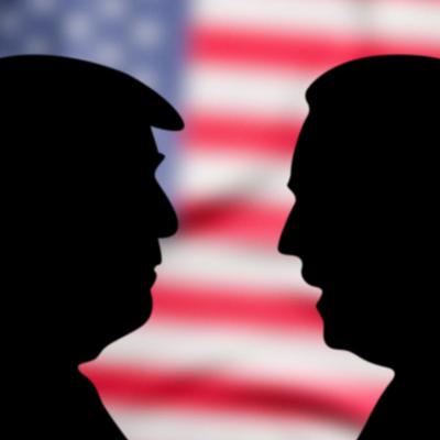 A black silhouette of Trump and Biden's profiles with a U.S. flag background.