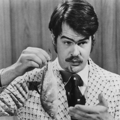 Canadian-American comedian Dan Aykroyd prepares to demonstrate the 'Super Bass-O-Matic' on a sketch from the TV comedy show 'Saturday Night Live', 1976.