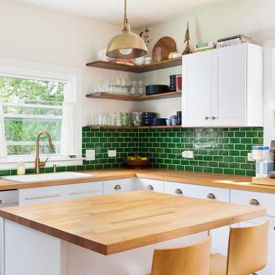 A photo of a remodeled modern kitchen with green, white and wooden interiors and fully furnished.