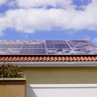 Solar panels on spanish tile roof with white spots of broken glass damaged from hailstorm. 