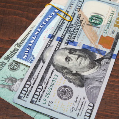 U.S. Treasury check, social security card and hundred dollar bills displayed on tabletop as concept of elements of ID theft scams. 
