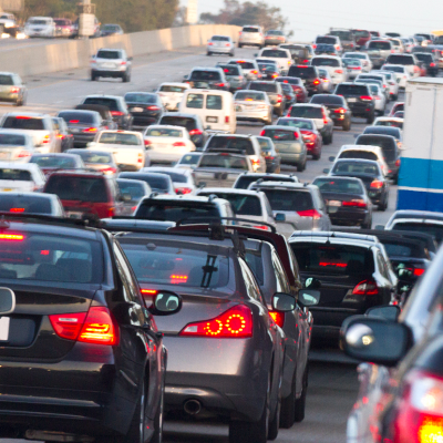 View of back of many cars on a congested highway. 