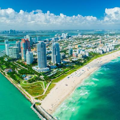 An aerial view of the blue-green ocean and skyline of South Beach, Miami. 