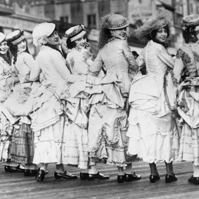 A group of women dressed in bustle gowns on the boardwalk in the 1890s.