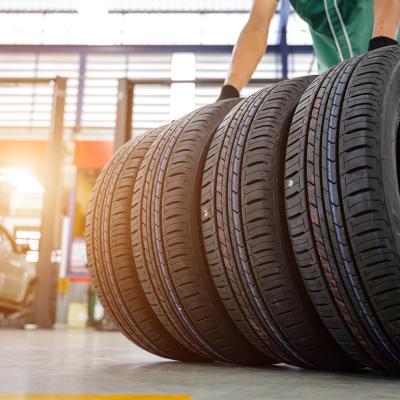 A worker gets a hold of four tires inside a car service establishment.