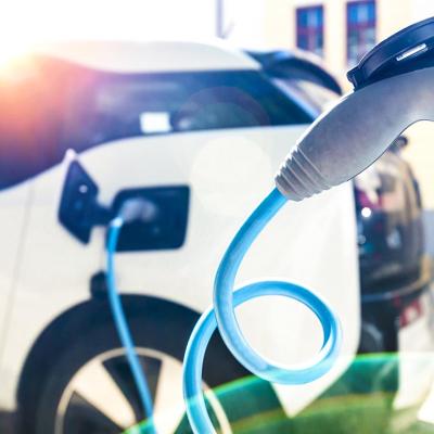 Closeup of an EV's charger nozzle while the car is being recharged at a station.