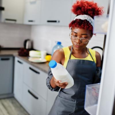 Woman holding a carton of milk from the refrigerator.