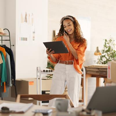 Small business owner talking on the phone and looking at business data.