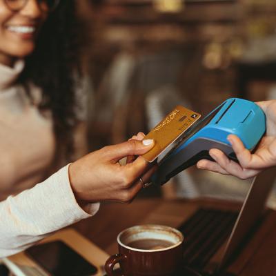 A woman taps her credit card in a restaurant's payment terminal.