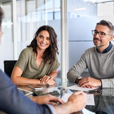 Smiling mature couple meeting with financial advisor.