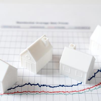 Four pieces of 3D models of houses over an investment chart.