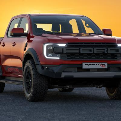A red 2023 Ford Ranger Raptor with the sun setting in the background.
