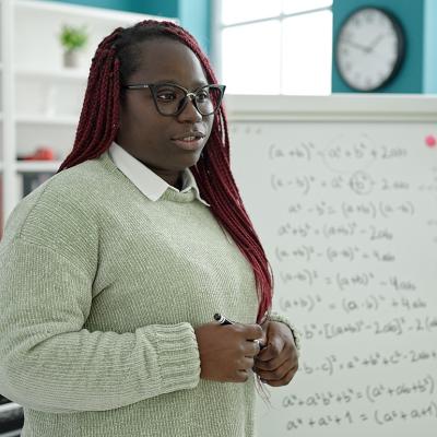 A black female teacher holding lessons in mathematics in a classroom.