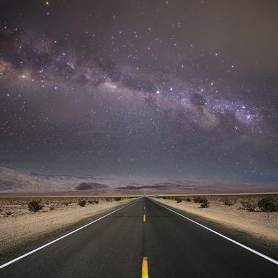 A starry night sky and road lines in a death valley desert in California, USA.