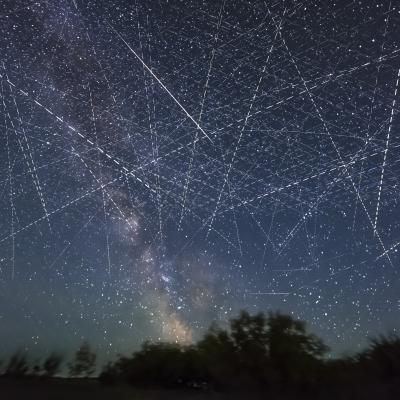Long-exposure taken over 30 seconds showing many satellites moving across the night sky appearing as dotted lines.
