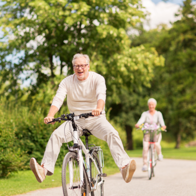 Happy senior couple riding bicycles in the park