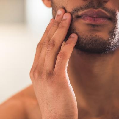 Closeup on a man touching his beard.