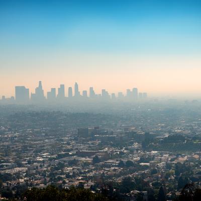 A foggy view of the downtown skyscraper buildings and suburbs of Los Angeles from Griffith Park in California.