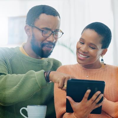 A black couple using a tablet at home to look up information.