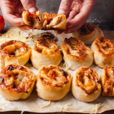 Pepperoni pizza rolls on a baking sheet.