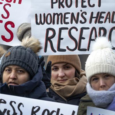 People gather on the University of Illinois Chicago (UIC) campus holding signs to protest the potential loss of federal funding for medical research.