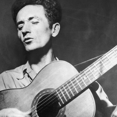 Woody Guthrie playing the guitar.