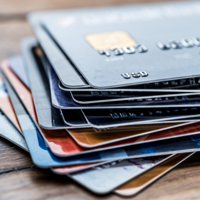 A stack of credit cards resting on a wooden table
