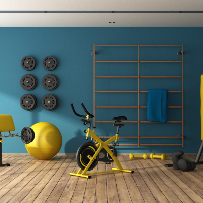 A home gym with fitness equipment, including weights on the wall, a weight bench, an exercise ball, a stationary bike, and punching bag.