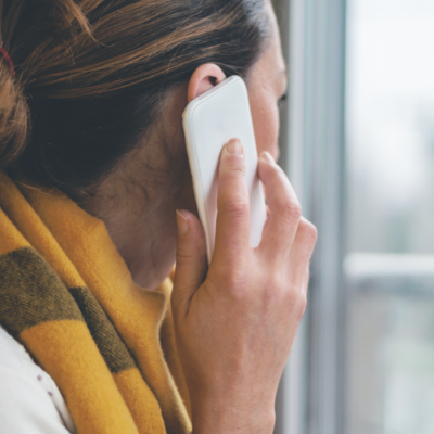 A woman on a phone call looking out a window.