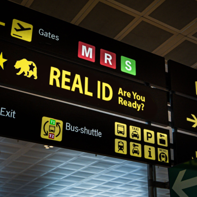 Illuminated airport signage displaying the Real ID compliance to remind airport visitors about new travel document requirements.