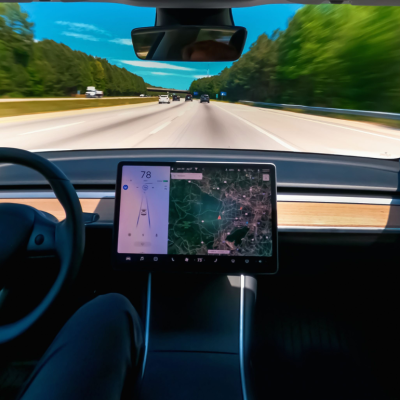 An interior view of a Tesla driving down a highway.