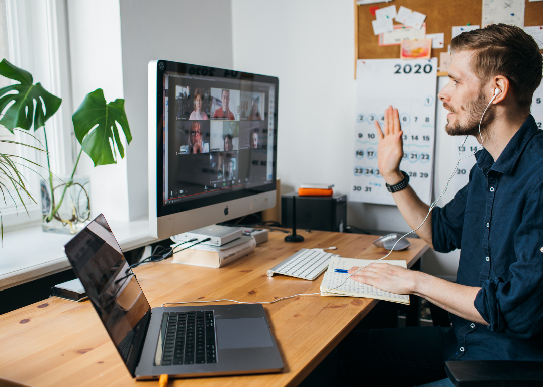 An employee on a video conferencing call via a computer in their home office