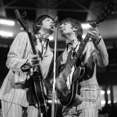 Beatles band members Paul McCartney (left), on bass, and John Lennon (right), on guitar, perform onstage at Olympia Stadium in Detroit, Michigan, in 1966.
