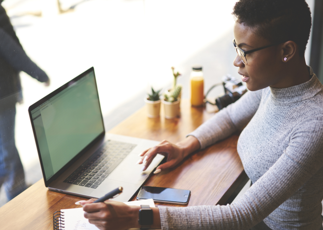 A woman works on a laptop in a cafe.