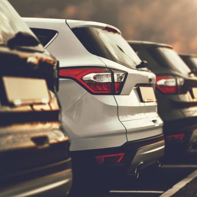 A line of small SUV's with ominous sky in background.