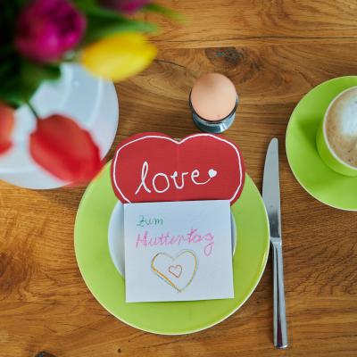 Aerial view of "Happy Mother's Day" and "love" in German on homemade cards