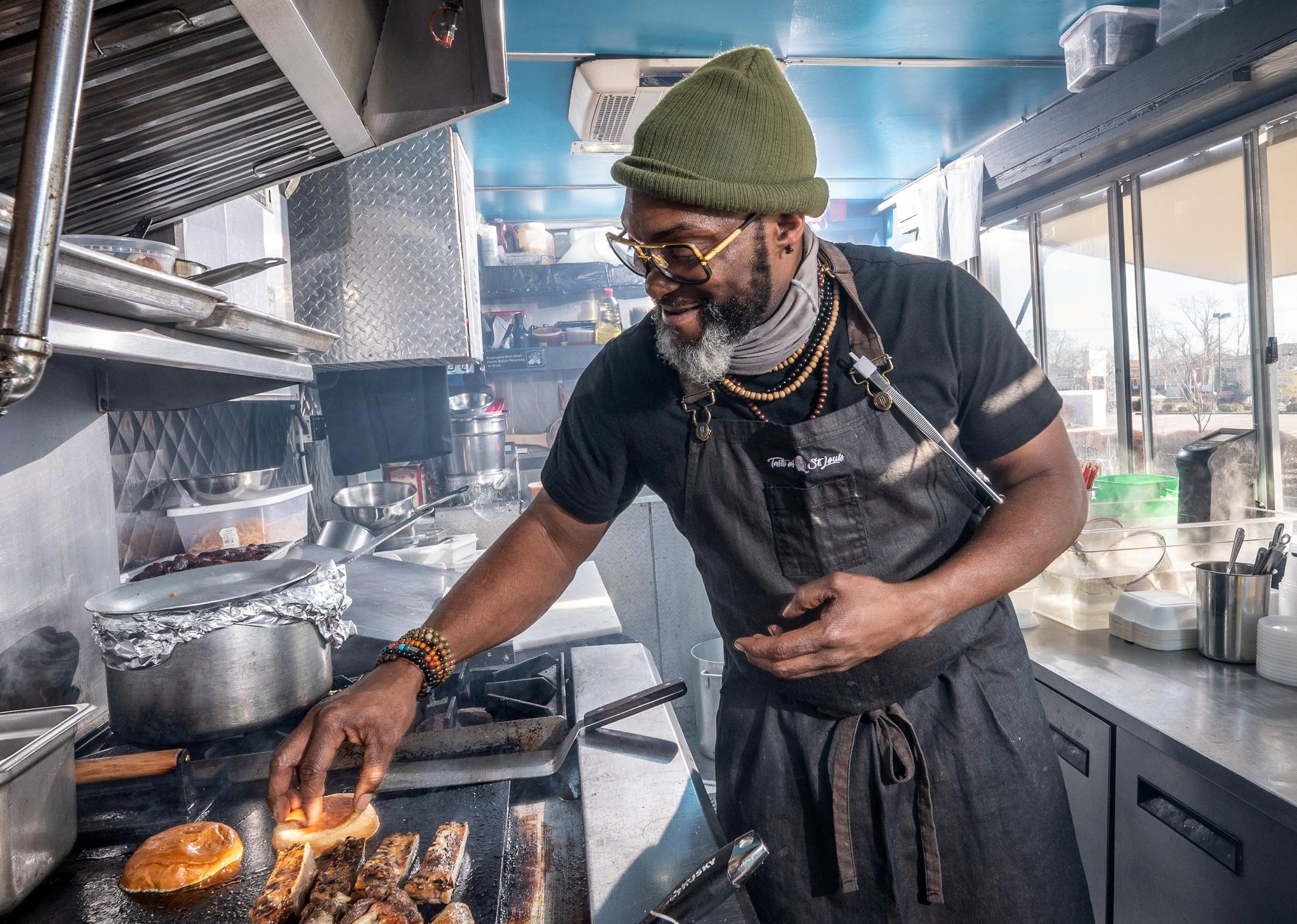 Chef Marc Bynum in his Hush food truck preparing food on his grill.