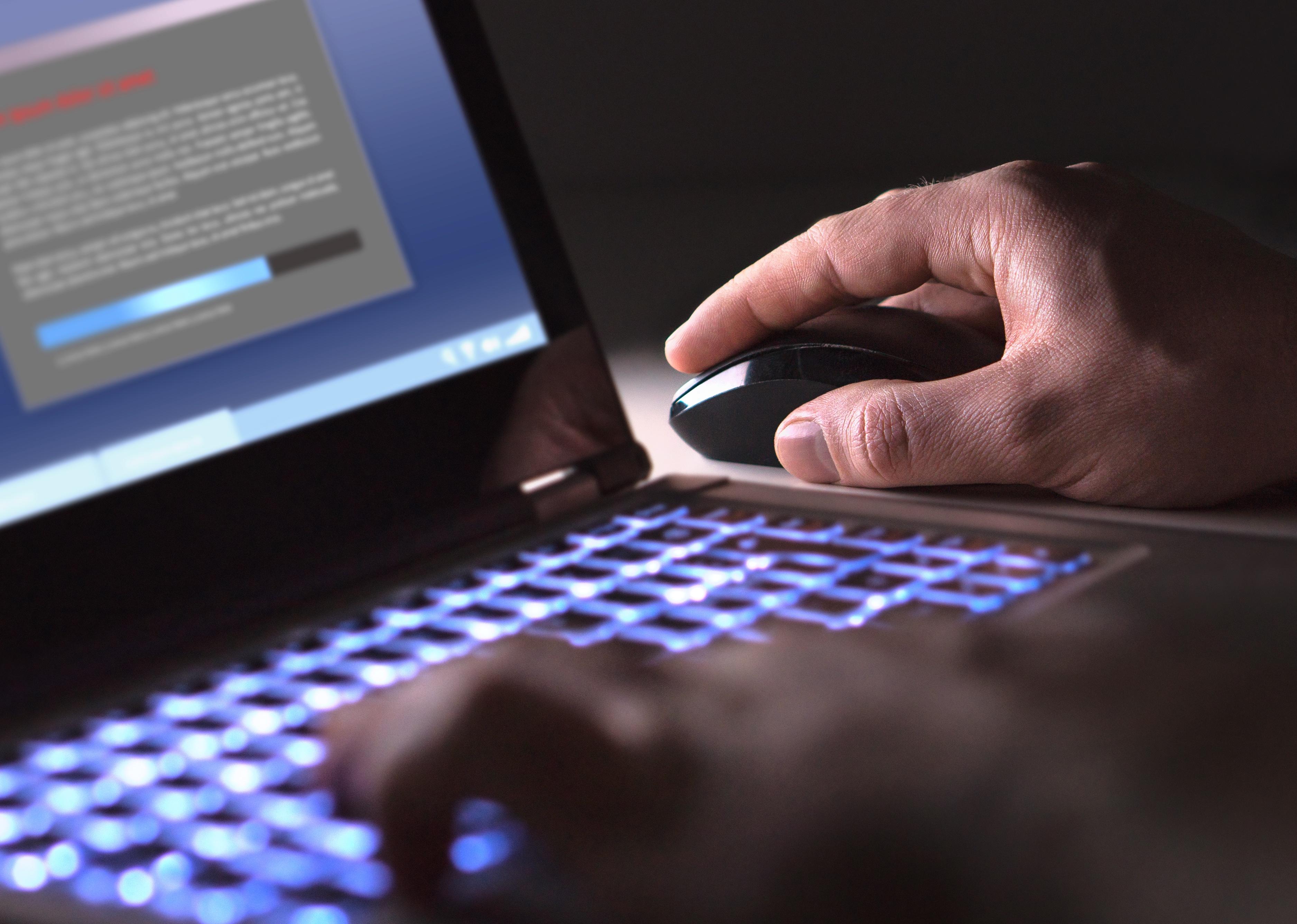 Man installing software in laptop in dark at night