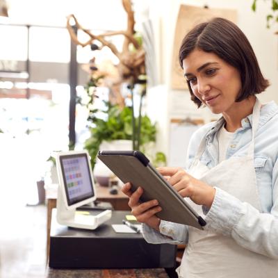 Female with tablet behind sales desk of florist store
