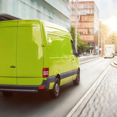 Green cargo van driving in the city