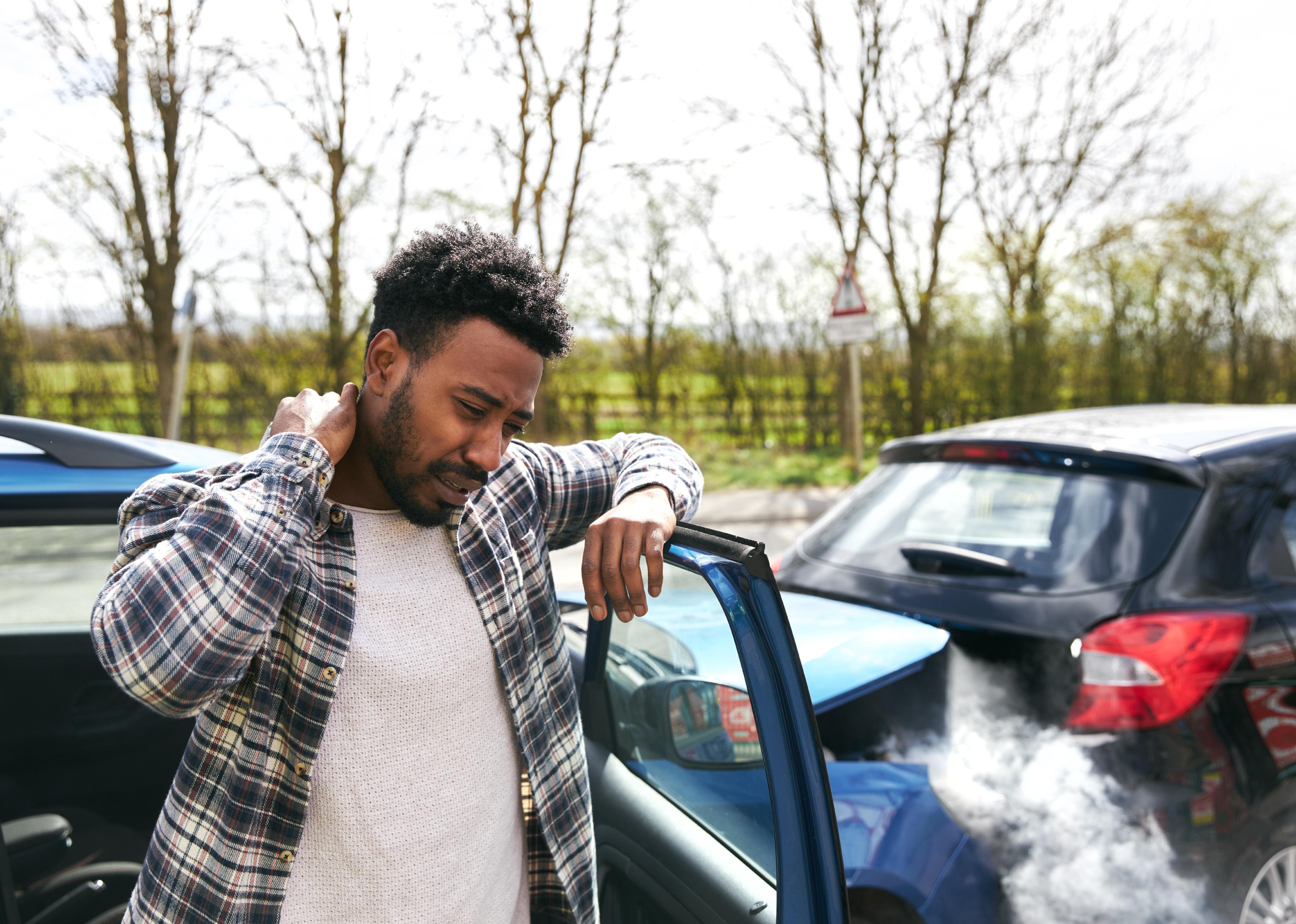Driver rubbing neck in pain from whiplash injury.