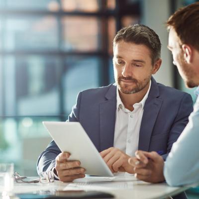 Two coworkers looking at a tablet.