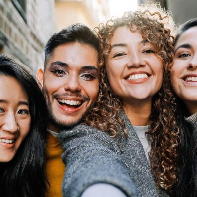 Diverse group of friends taking selfie outdoors.