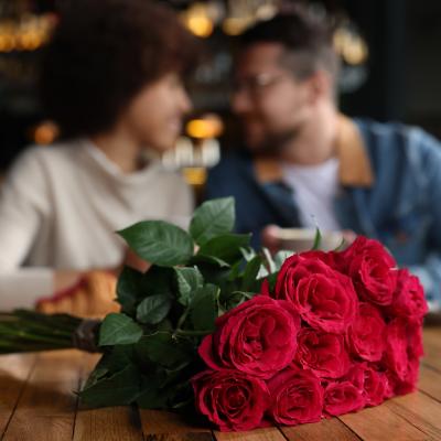 Focus on roses in front of a happy couple.