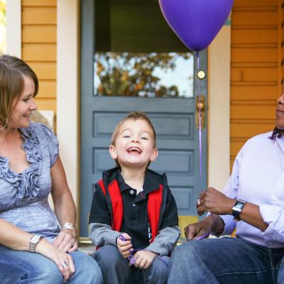 Two women and their son sitting on porch