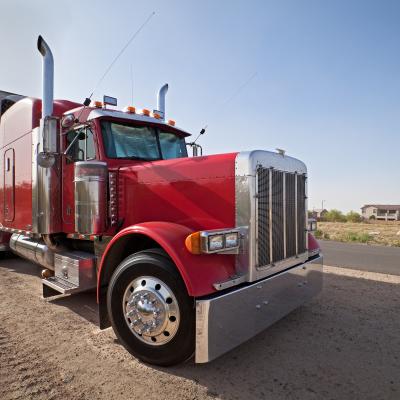 Red semitruck parked on the side of the road.