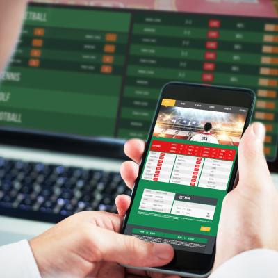Businessman using smartphone with gambling app.