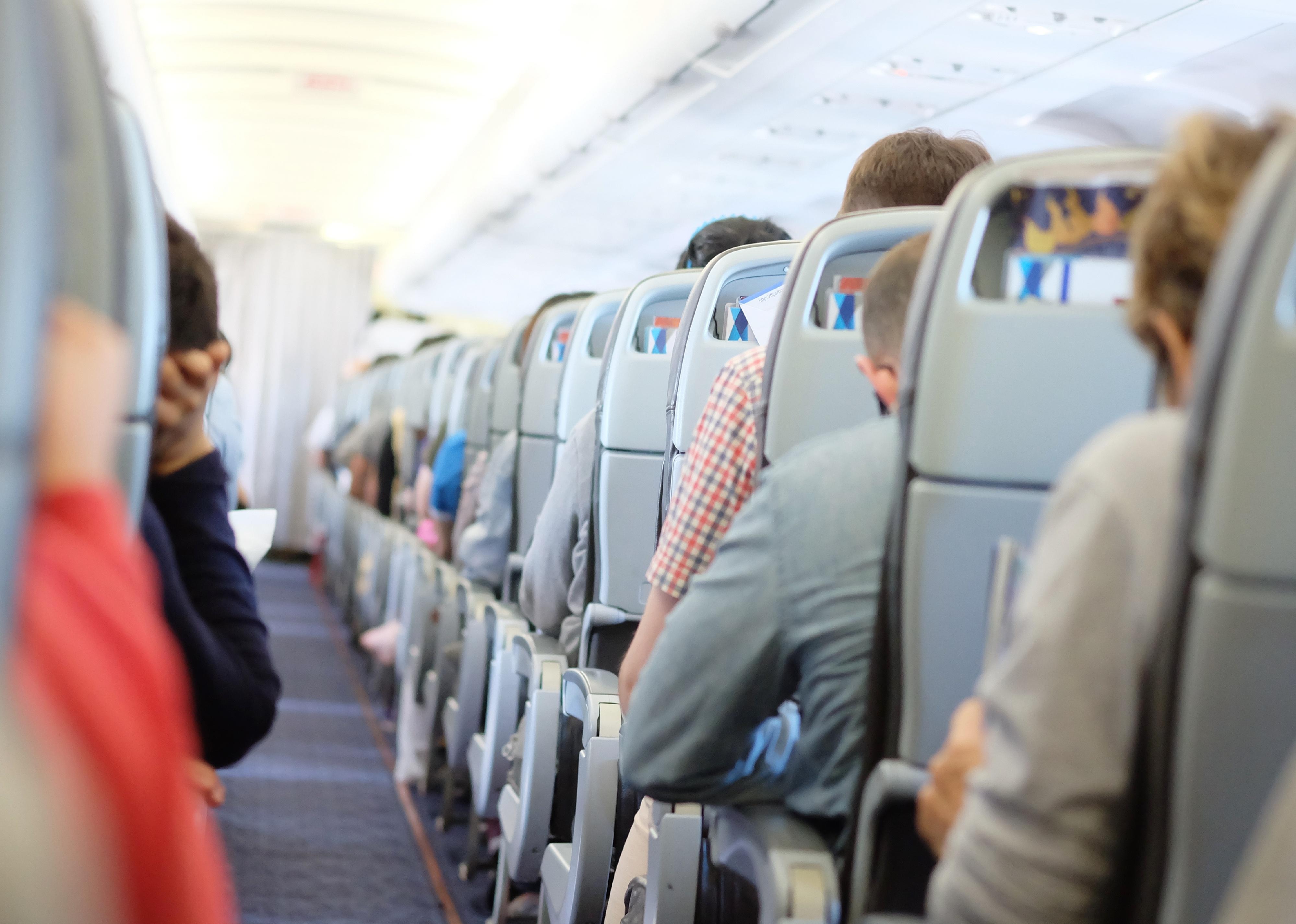Passengers sitting and sleeping on an airplane.