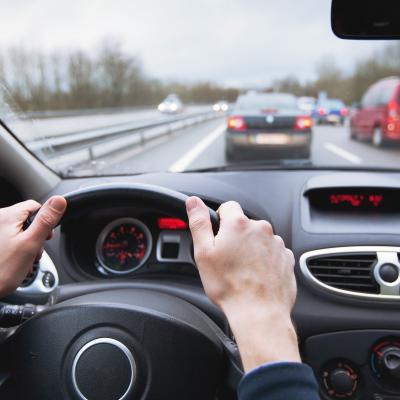 Close-up of hands on a steering wheel.